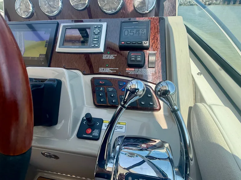 Slide: The Image of The image shows the dashboard of a 2009 Sea Ray Sundancer 310 with various instruments and throttle controls. - 11