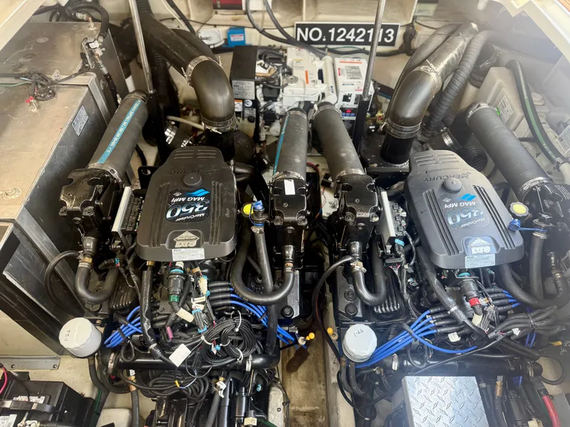 Slide: The Image of The engine room of a 2009 Sea Ray Sundancer 310 features two powerful engines and wiring. - 21