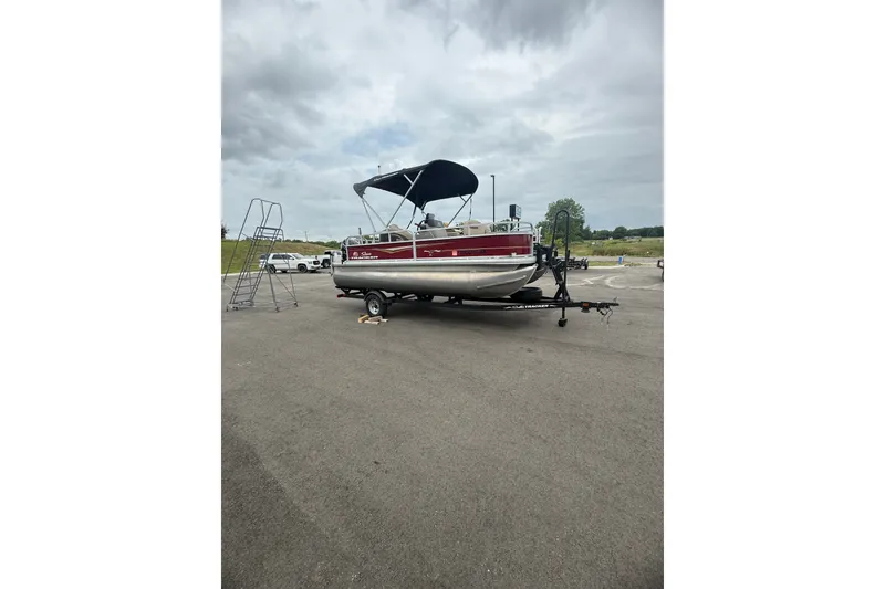 The Image of 2021 SUNTRACKER Bass Buggy 18DLX pontoon boat on trailer, parked outdoors. - 1