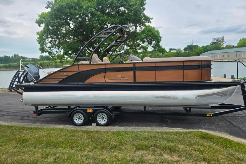 Slide: The Image of 2017 Bennington G 23 GSBA pontoon boat on trailer by a lakeside. - 9