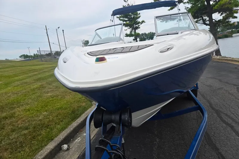 Slide: The Image of 2005 Yamaha Boats SX230 on trailer, parked near a grassy area by the water. - 6