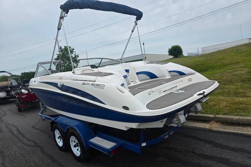 Slide: The Image of 2005 Yamaha Boats SX230 on trailer, blue and white design, parked outdoors. - 3