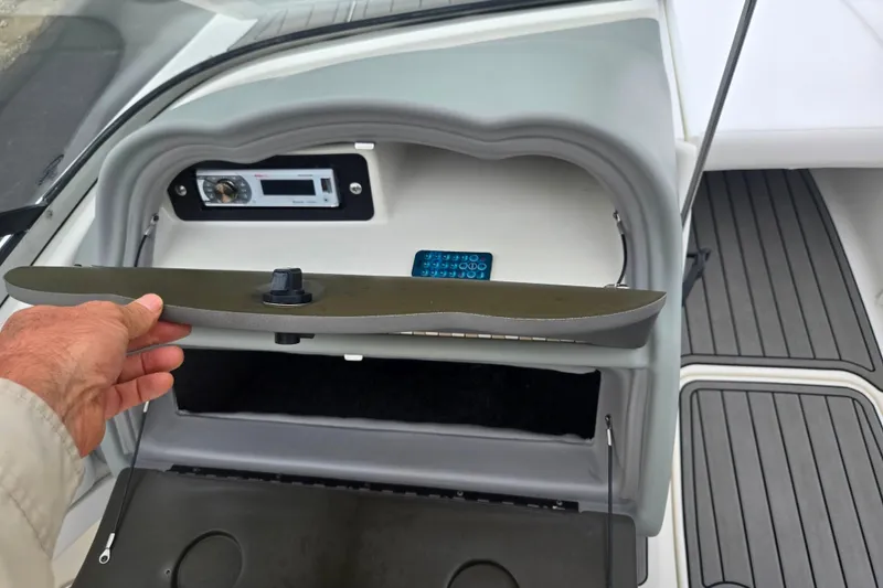 Slide: The Image of 2005 Yamaha Boats SX230 dashboard with stereo system and storage compartment. - 15