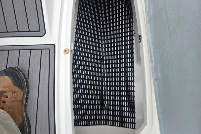 Slide: The Image of 2005 Yamaha Boats SX230 interior with non-slip flooring and storage compartment. - 12