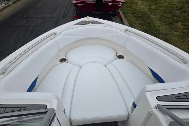 Slide: The Image of 2005 Yamaha Boats SX230 bow seating area with white upholstery and cup holders. - 16