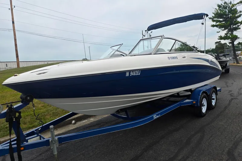 Slide: The Image of 2005 Yamaha Boats SX230 on trailer, blue and white, parked on road. - 5