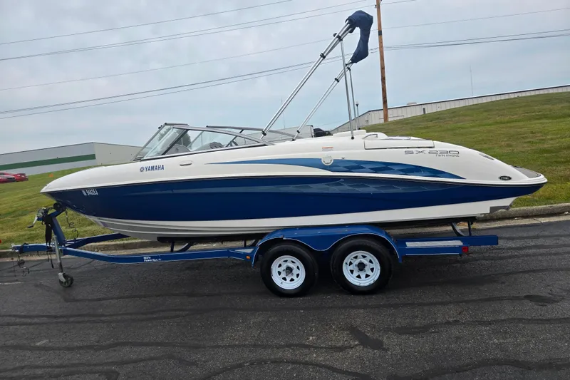 Slide: The Image of 2005 Yamaha Boats SX230 on trailer, blue and white design, parked on roadside. - 4