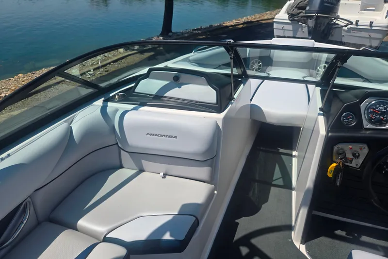 Slide: The Image of 2012 Moomba Mojo 2.5 boat interior with sleek seating and dashboard by the water. - 12