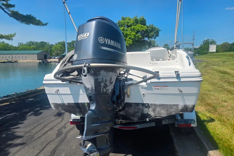 Slide: The Image of 2013 Hurricane SunDeck Sport 188 OB boat with Yamaha 150 engine by a lakeside. - 2