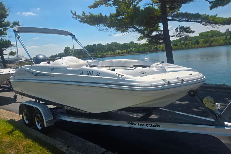 Slide: The Image of 2013 Hurricane SunDeck Sport 188 OB boat on trailer by a lake. - 8