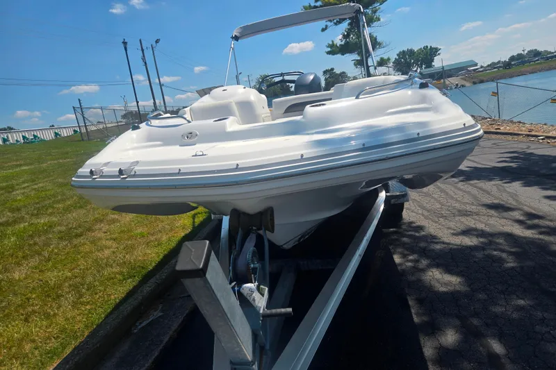 Slide: The Image of 2013 Hurricane SunDeck Sport 188 OB boat on trailer, sunny day, near water. - 6