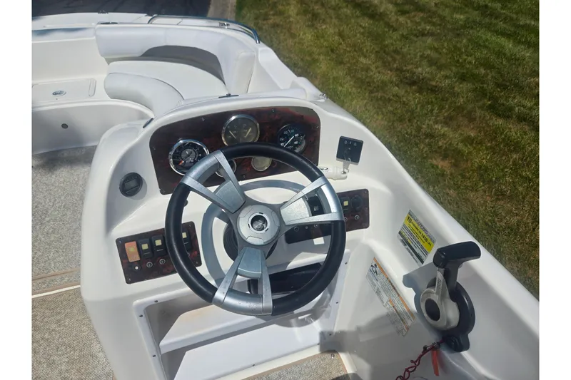 Slide: The Image of 2013 Hurricane SunDeck Sport 188 OB boat dashboard with steering wheel and controls. - 19
