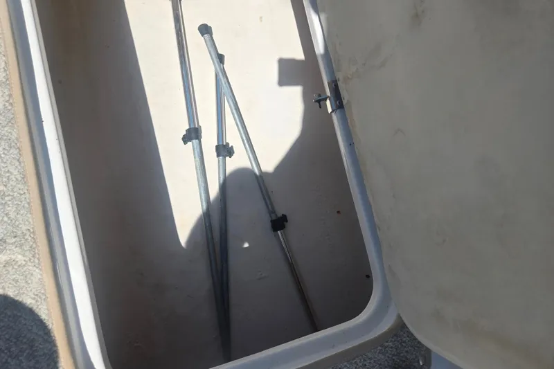 Slide: The Image of Open storage compartment with metal poles inside, 2013 Hurricane SunDeck Sport 188 OB. - 21