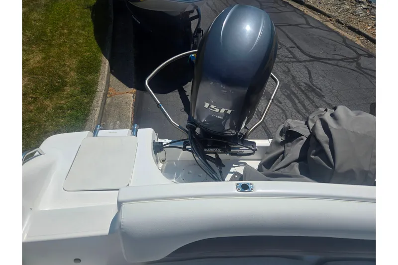 Slide: The Image of 2013 Hurricane SunDeck Sport 188 OB with 15 HP outboard motor, parked on pavement. - 15