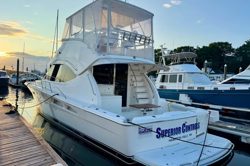 Slide: The Image of 2009 Riviera 45 Open Flybridge yacht docked at sunset, featuring sleek design and spacious flybridge. - 5