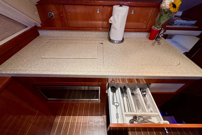 Slide: The Image of Luxurious 2009 Riviera 45 Open Flybridge yacht kitchen with countertop, utensils, and flowers. - 40
