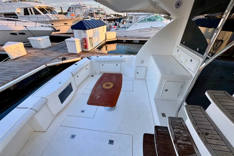 Slide: The Image of 2009 Riviera 45 Open Flybridge yacht deck with seating and wooden table at marina. - 16