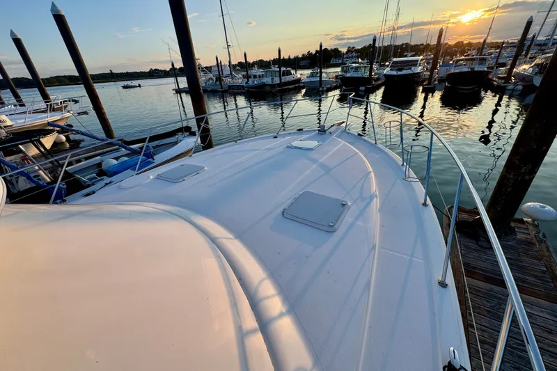 Slide: The Image of 2009 Riviera 45 Open Flybridge yacht docked at sunset in a serene marina. - 9