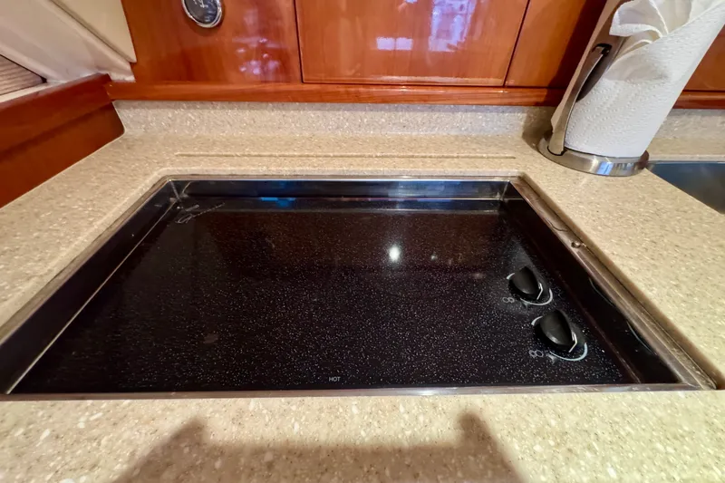Slide: The Image of Stovetop in 2009 Riviera 45 Open Flybridge yacht kitchen, featuring sleek countertop design. - 36