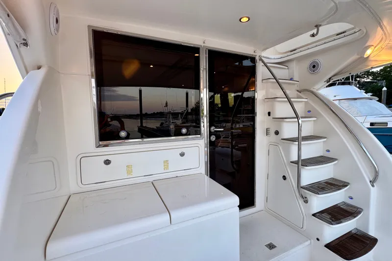Slide: The Image of 2009 Riviera 45 Open Flybridge yacht with elegant staircase and sleek design at sunset. - 15