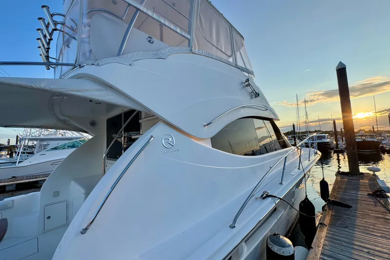Slide: The Image of 2009 Riviera 45 Open Flybridge yacht docked at sunset, showcasing sleek design and elegance. - 7