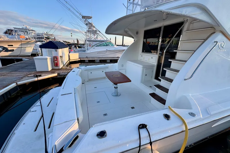 Slide: The Image of 2009 Riviera 45 Open Flybridge yacht docked, featuring spacious deck and elegant design. - 6