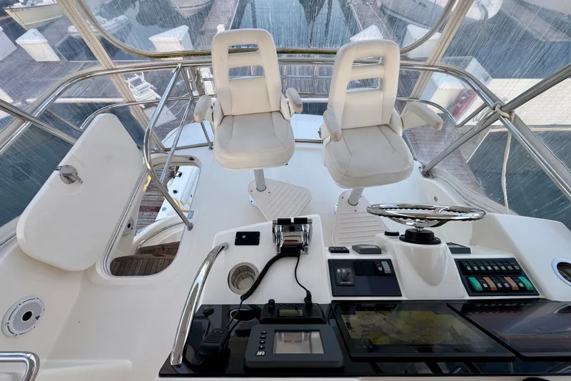 Slide: The Image of 2009 Riviera 45 Open Flybridge helm with dual seats and navigation controls. - 20