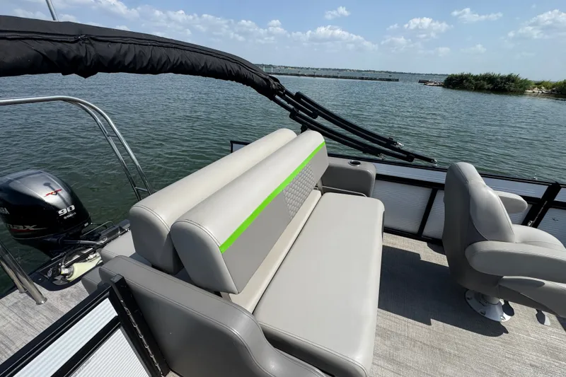 Slide: The Image of 2023 Qwest Lanai 820 pontoon boat interior with seating and Yamaha engine on a lake. - 15