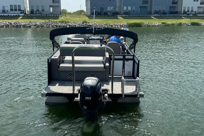 Slide: The Image of 2023 Qwest Lanai 820 pontoon boat on water, rear view with outboard motor. - 3