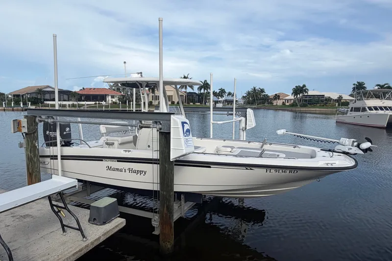 Slide: The Image of 2016 Boston Whaler 240 Dauntless boat docked by waterfront homes. - 1
