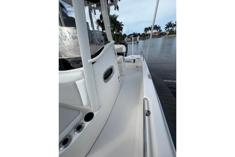 Slide: The Image of 2016 Boston Whaler 240 Dauntless boat docked by a serene waterfront. - 12