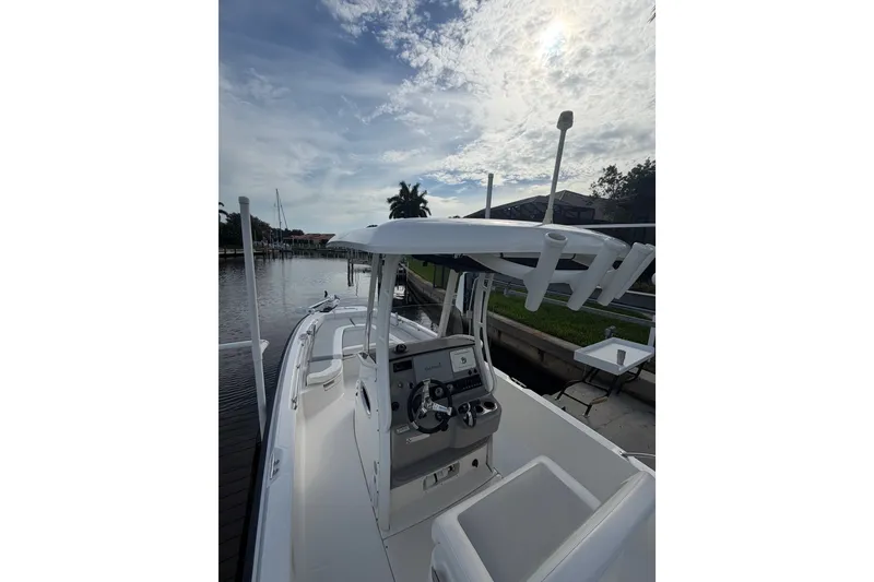 Slide: The Image of 2016 Boston Whaler 240 Dauntless boat docked under a cloudy sky. - 17
