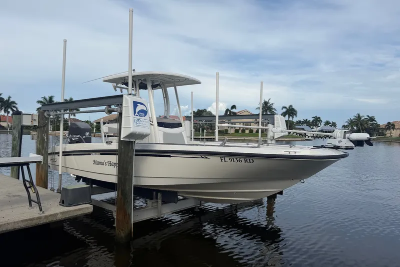 The Image of 2016 Boston Whaler 240 Dauntless boat docked on a lift by a waterfront property. - 0