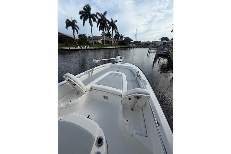 Slide: The Image of 2016 Boston Whaler 240 Dauntless boat on a calm canal with palm trees. - 6