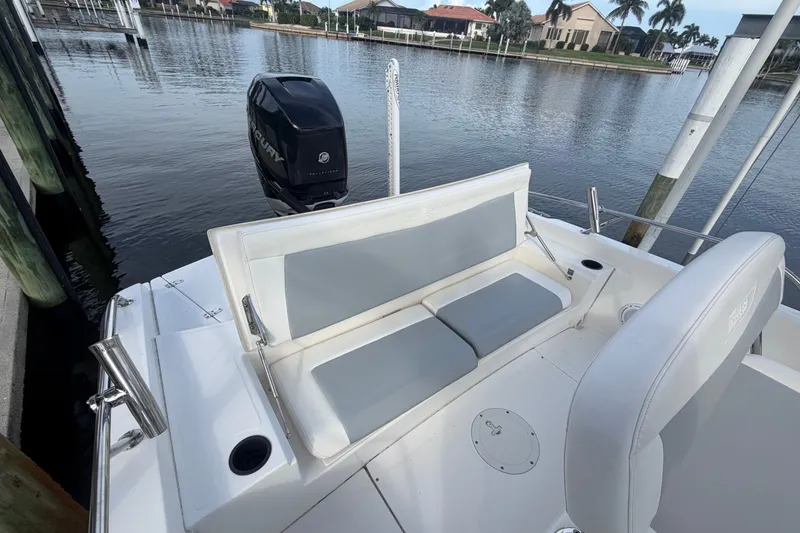 Slide: The Image of 2016 Boston Whaler 240 Dauntless boat with cushioned seating and Mercury outboard motor. - 22