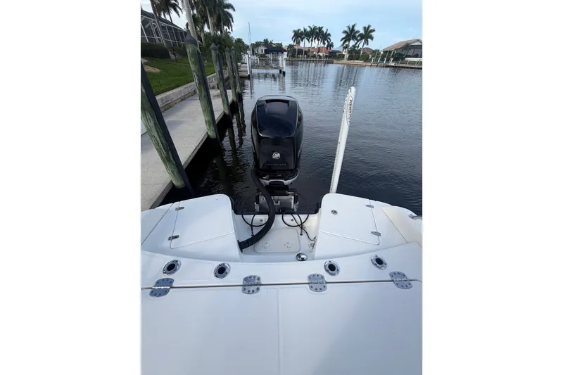 Slide: The Image of 2016 Boston Whaler 240 Dauntless boat docked, showcasing rear deck and outboard motor. - 24
