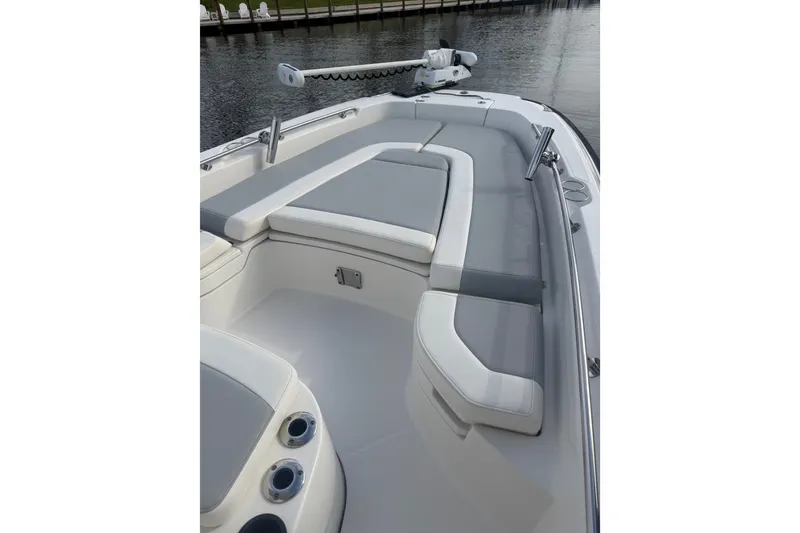 Slide: The Image of 2016 Boston Whaler 240 Dauntless boat interior with cushioned seating and water view. - 5