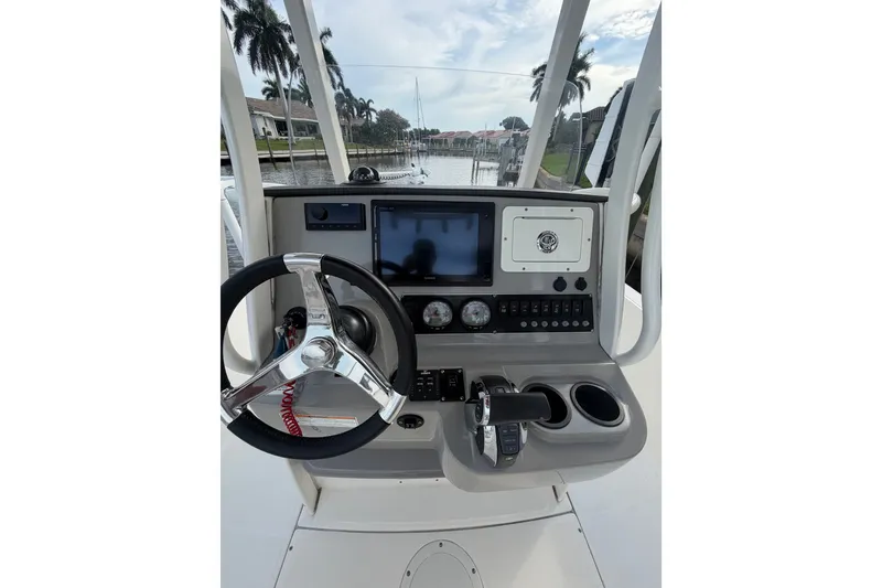 Slide: The Image of 2016 Boston Whaler 240 Dauntless helm with steering wheel, controls, and navigation display. - 19
