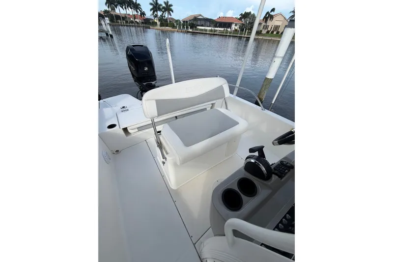 Slide: The Image of 2016 Boston Whaler 240 Dauntless boat interior with seating and control panel by the water. - 21