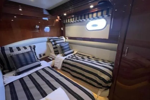 Slide: The Image of Luxurious twin cabin interior of 2008 Marquis 65 Skylounge yacht with striped bedding. - 68
