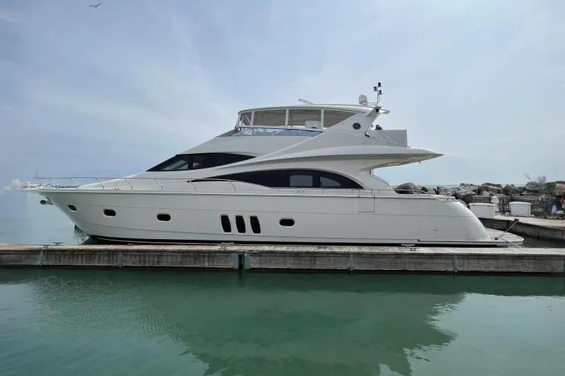 The Image of 2008 Marquis 65 Skylounge yacht docked in a serene marina setting. - 0