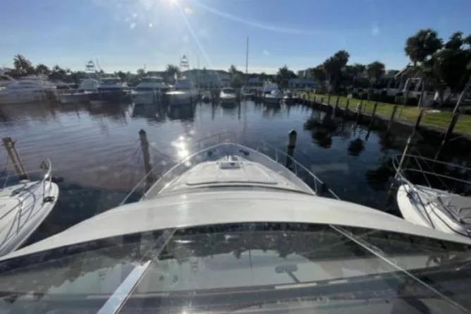 Slide: The Image of 2008 Marquis 65 Skylounge yacht docked in a sunny marina, surrounded by water and boats. - 33
