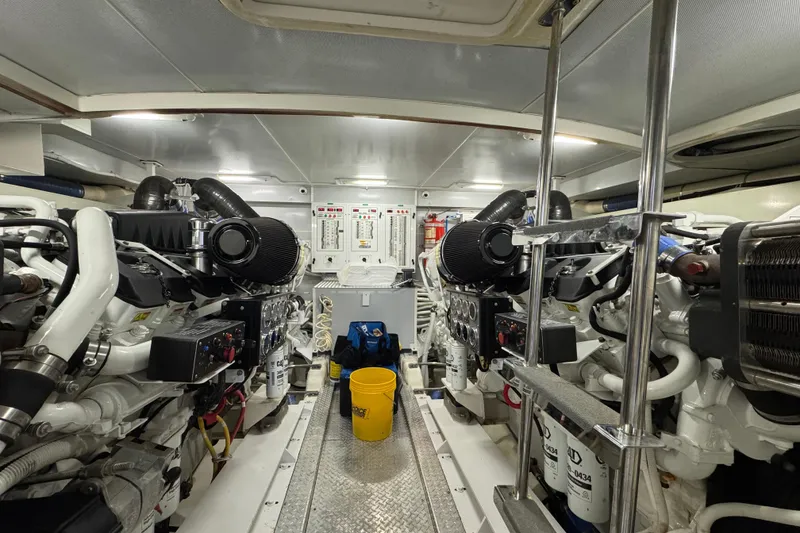 Slide: The Image of Engine room of a 2008 Marquis 65 Skylounge yacht, featuring dual engines and maintenance equipment. - 79