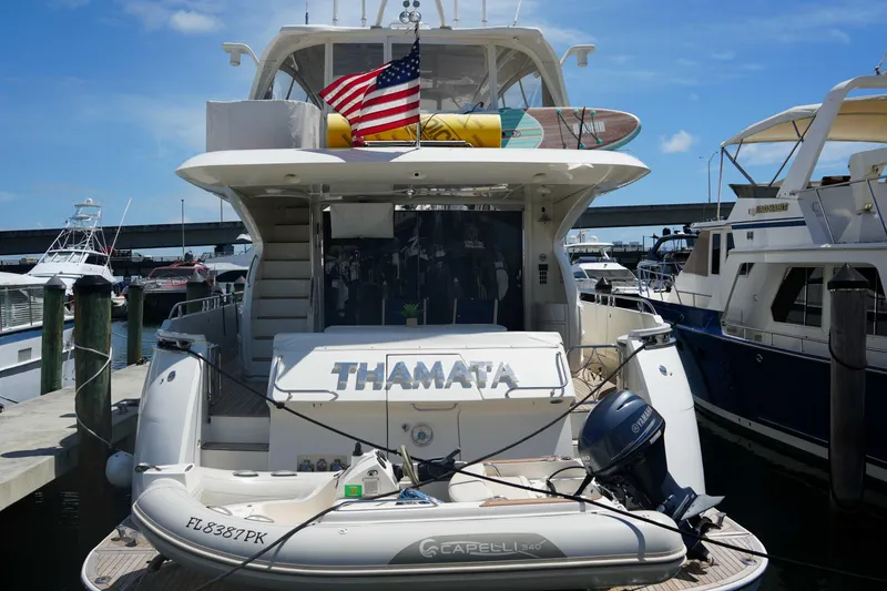 Slide: The Image of Luxury yacht Marquis 65 Skylounge 2008 docked, featuring American flag and inflatable boat. - 1