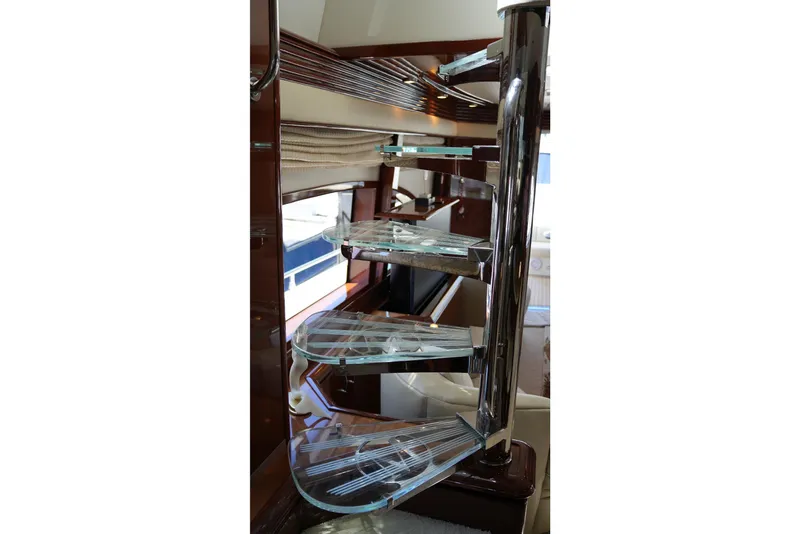 Slide: The Image of Spiral staircase inside 2008 Marquis 65 Skylounge yacht, featuring sleek glass steps and polished metal railing. - 41