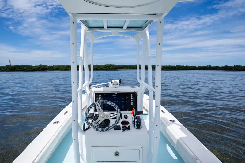 Slide: The Image of 2018 Dorado 25 SE boat console on calm water under blue sky. - 30