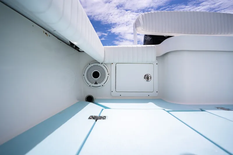 Slide: The Image of Interior view of 2018 Dorado 25 SE boat, featuring white seating and storage compartment. - 59