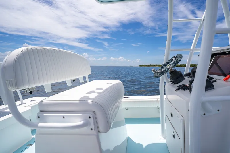 Slide: The Image of 2018 Dorado 25 SE boat interior with white seating, steering wheel, and ocean view. - 35