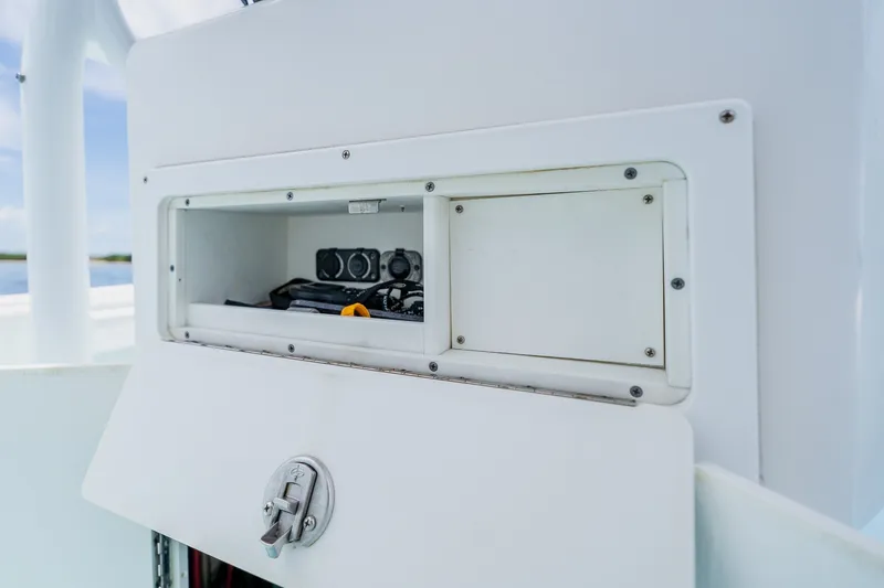 Slide: The Image of Storage compartment on a 2018 Dorado 25 SE boat, featuring secure latch and interior equipment. - 37