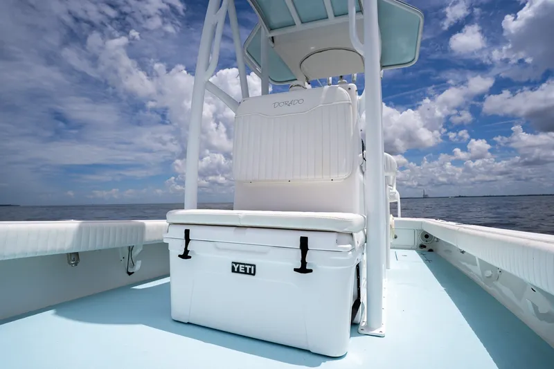 Slide: The Image of 2018 Dorado 25 SE boat with Yeti cooler on deck, under a partly cloudy sky. - 28
